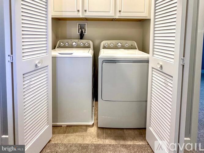 A laundry room with two front loading washing machines.