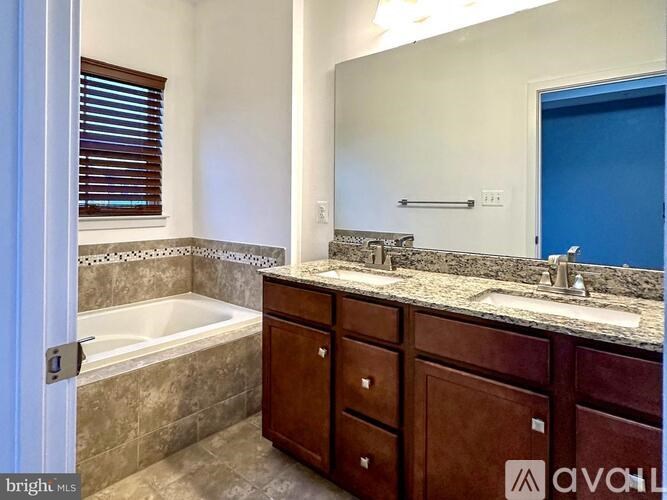 A bathroom with a tub, sink, and wooden cabinets.