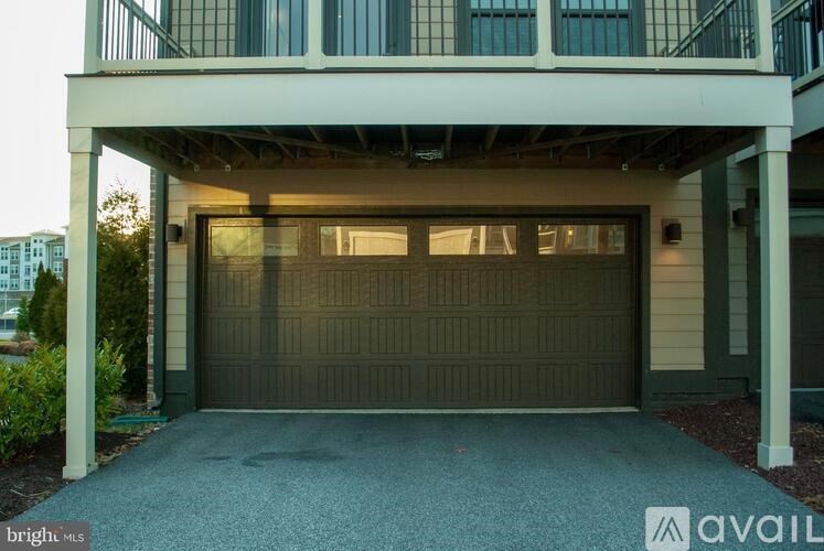 A house with a garage door and a balcony.