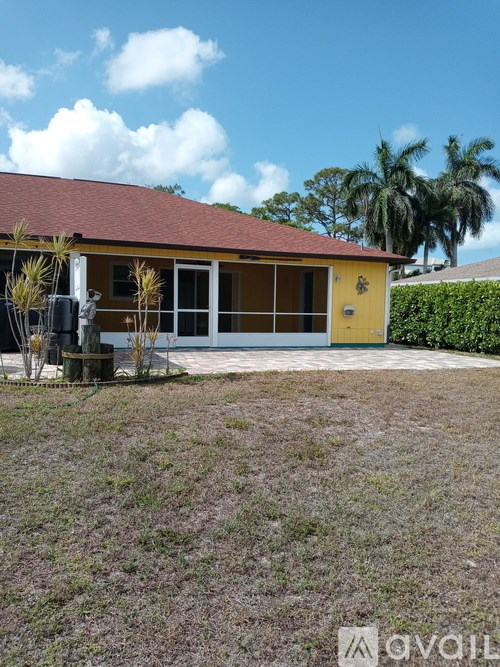 A yellow house with a red roof and a blue door.