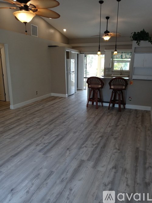 A room with wooden flooring and a ceiling fan.
