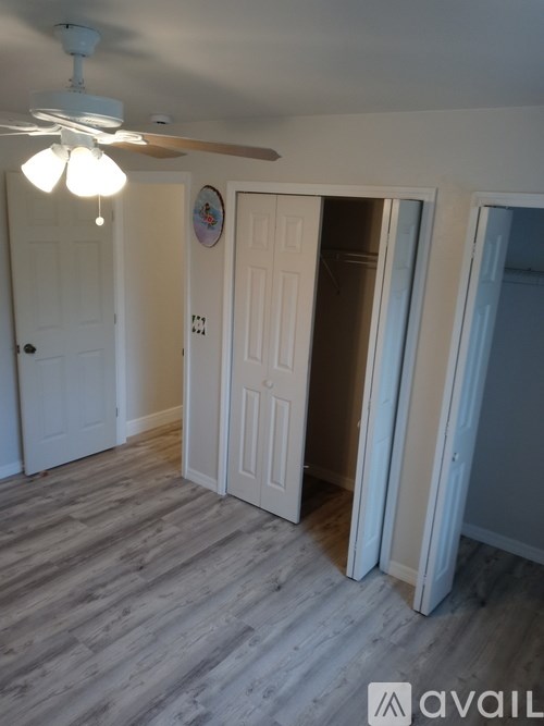 A room with a ceiling fan and a door with a number 231 on it.