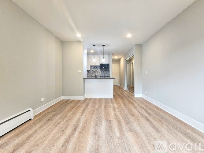 A spacious room with wooden flooring and a white countertop.