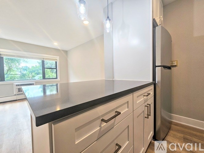 A kitchen with a black countertop and white cabinets.