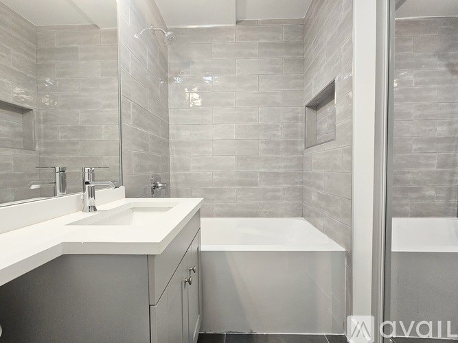 A modern bathroom with a white sink and a bathtub.