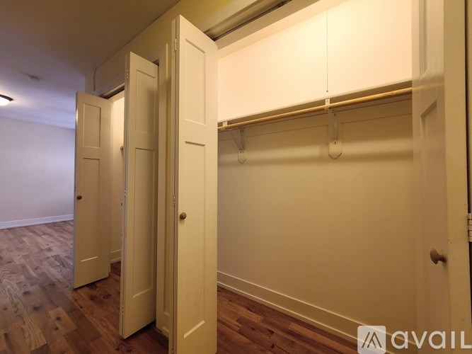 Closet with white doors and a coat rack.
