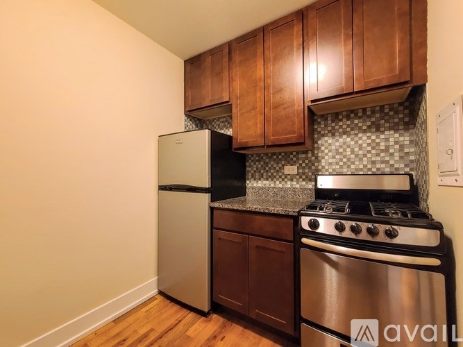 A kitchen with wooden cabinets and a stainless steel oven.