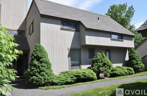 A house with a grey exterior and a grey roof with a small chimney.