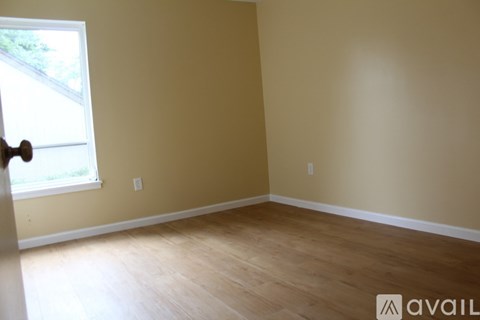 A room with wooden flooring and a window.