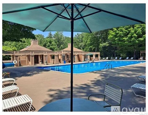 A pool area with sun loungers and a building in the background.