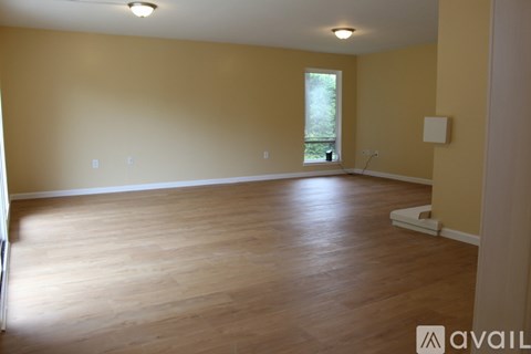 A room with wooden flooring and a window.