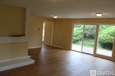 A spacious room with a fireplace and sliding glass doors.