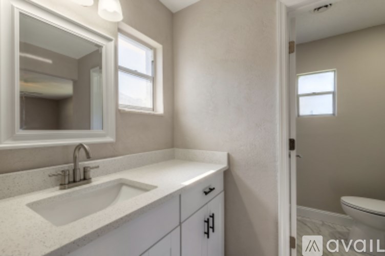 A bathroom with a sink, mirror, and toilet.