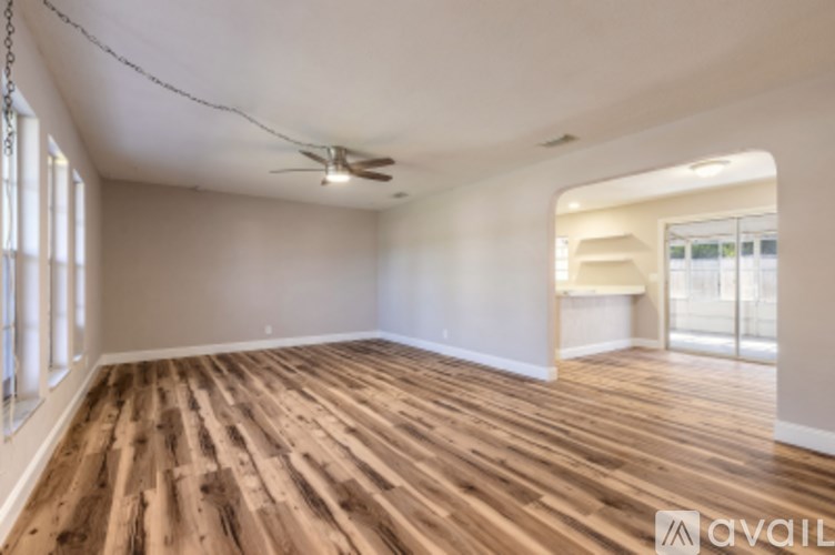 A room with wooden flooring and a ceiling fan.