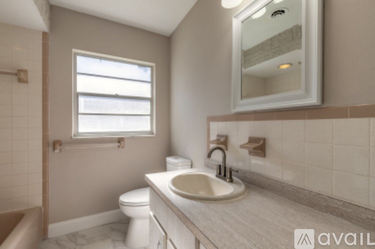 A bathroom with a toilet, sink, and window.
