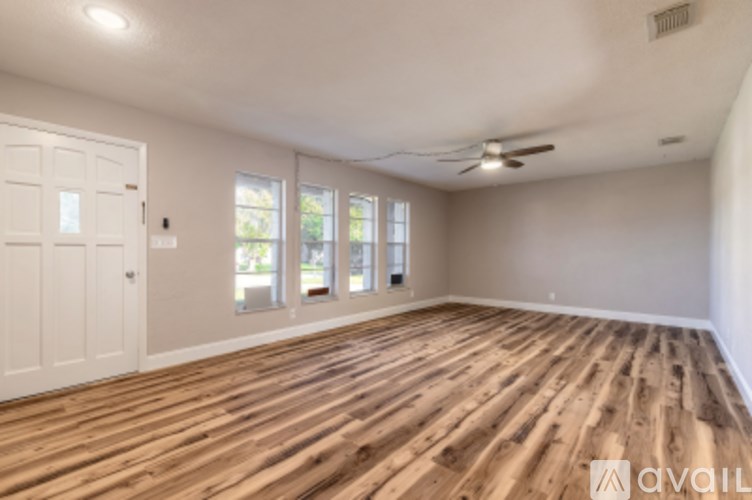 A room with wooden flooring and a white door.