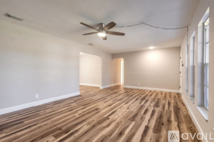 A room with wooden flooring and a ceiling fan.