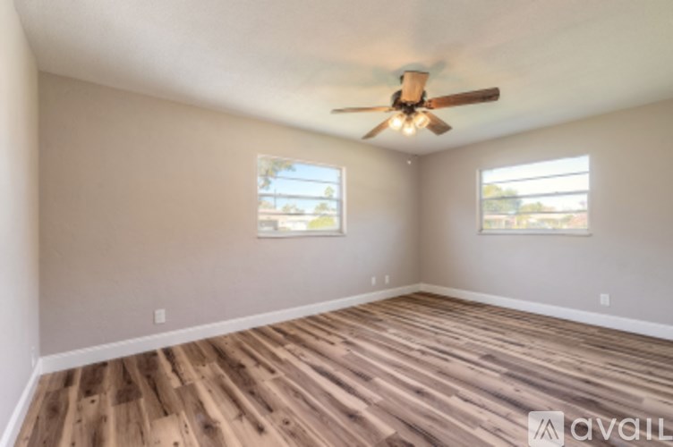 A room with wooden floors and a ceiling fan.