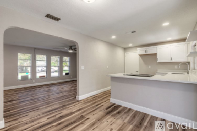 A kitchen with wooden floors and white cabinets is available.