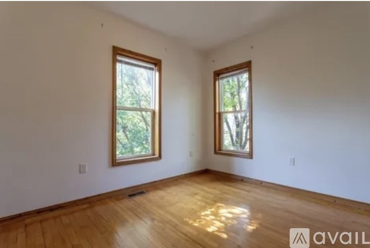 A room with wooden floors and two windows.