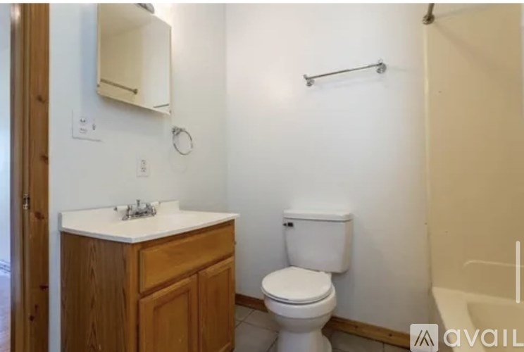A bathroom with a toilet, sink, and towel rack.