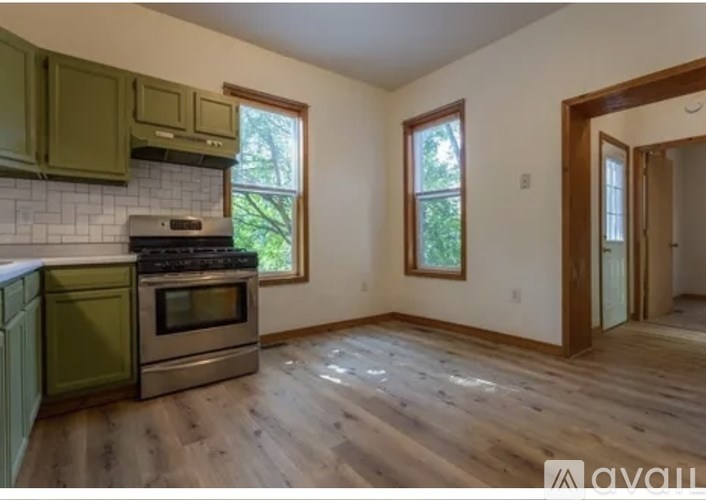 A kitchen with green cabinets and a stove top oven.