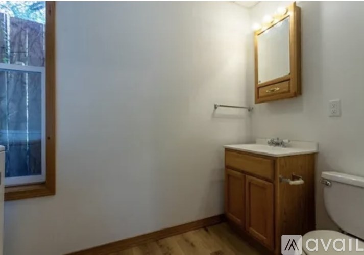 A bathroom with a wooden cabinet and a white sink.