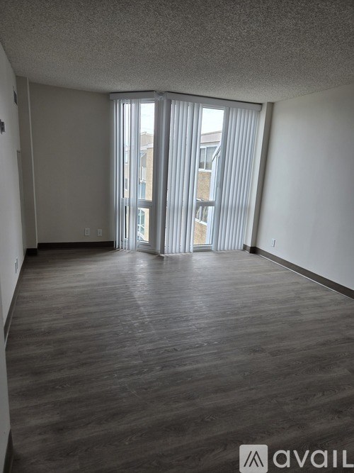 A room with wooden flooring and a sliding glass door.