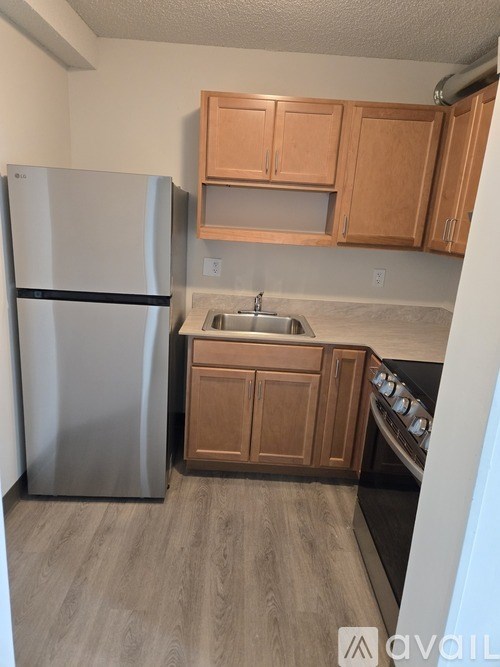 A kitchen with a refrigerator, sink, and oven.