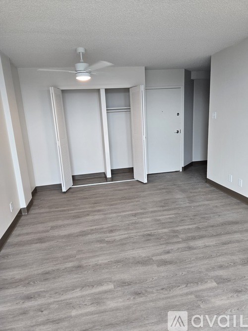 A room with a fan and a door with a window.