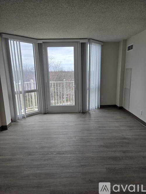 A spacious room with large windows and sliding doors leading to a balcony.