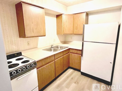 A kitchen with wooden cabinets and a white refrigerator.