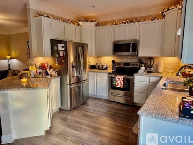 A kitchen with a refrigerator, oven, and microwave.