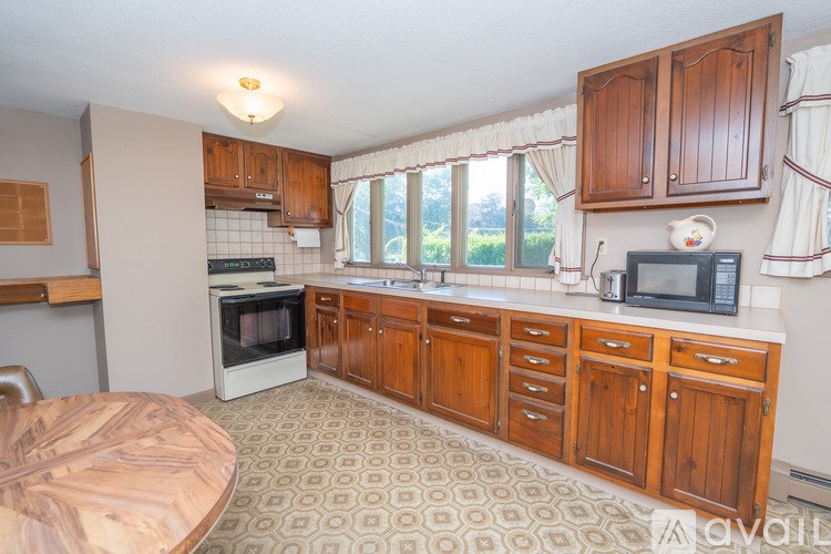A kitchen with wooden cabinets and a patterned floor.