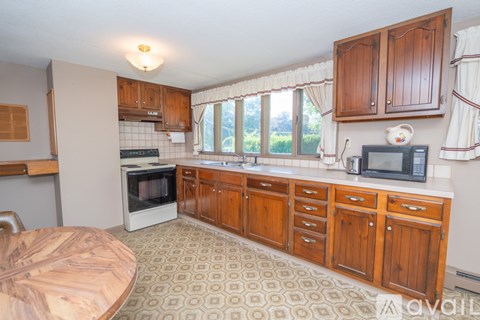 A kitchen with wooden cabinets and a patterned floor.