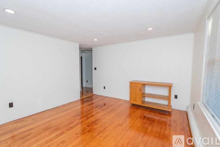 A room with wooden floors and a wooden cabinet.