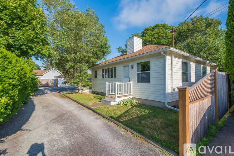 A house with a white exterior and a brown fence is shown.