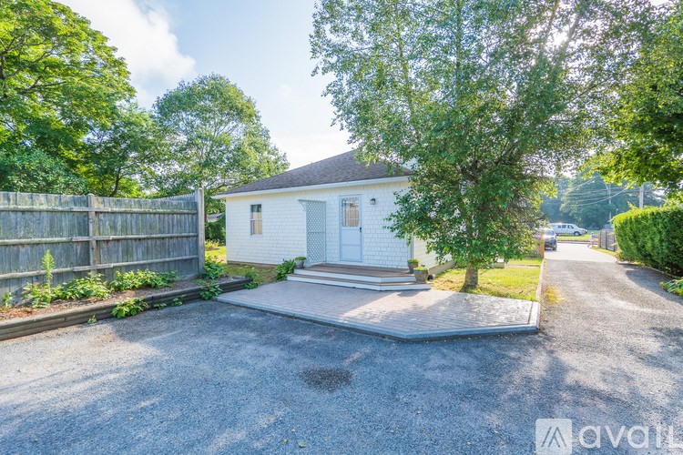 A white house with a gravel driveway in front.