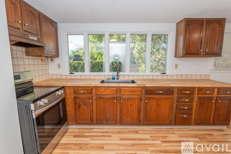 A kitchen with wooden cabinets and a stove top oven.