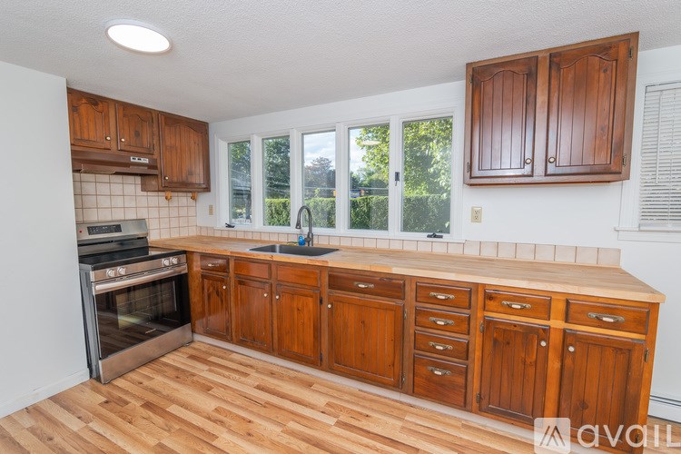 A kitchen with wooden cabinets and a stainless steel oven.