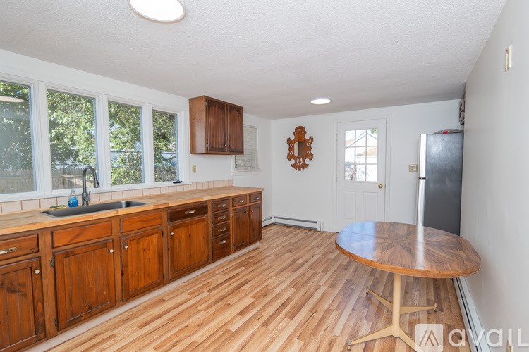 A kitchen with wooden floors and cabinets.