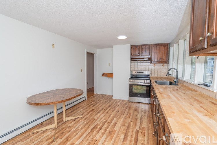 A kitchen with wooden floors and a round table.