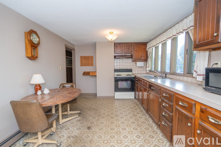A kitchen with a patterned floor and wooden furniture.