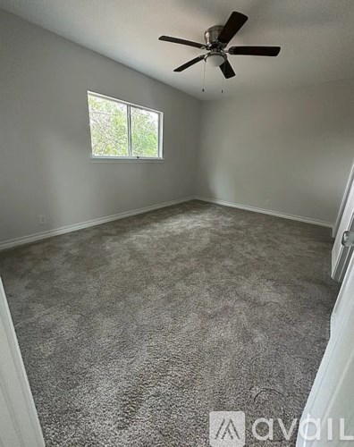 A room with a ceiling fan and a window.