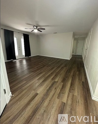 A room with wooden flooring and a ceiling fan.
