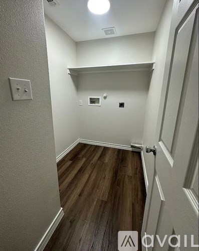 A hallway with wood floors and white walls.