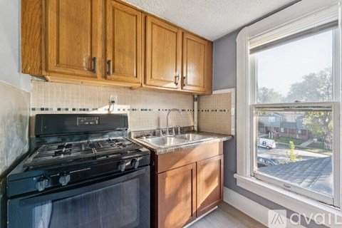 A kitchen with wooden cabinets and a black stove top oven.