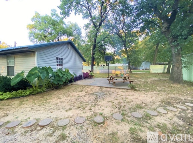 A backyard with a picnic table and a house.
