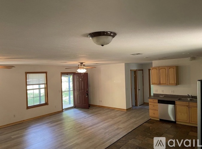 A kitchen with wooden cabinets and a stainless steel dishwasher.