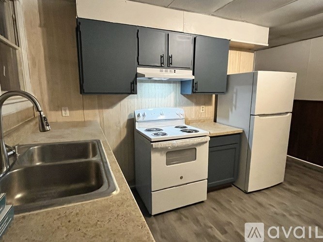 A kitchen with a sink, stove, and refrigerator.